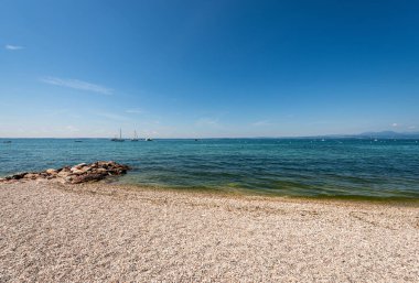 Cisano ve Bardolino 'nun küçük köyleri arasında Garda Gölü' nde (Lago di Garda) güzel bir sahil vardır. Verona ili, Veneto, İtalya, güney Avrupa. Ufukta Lombardy kıyısı.