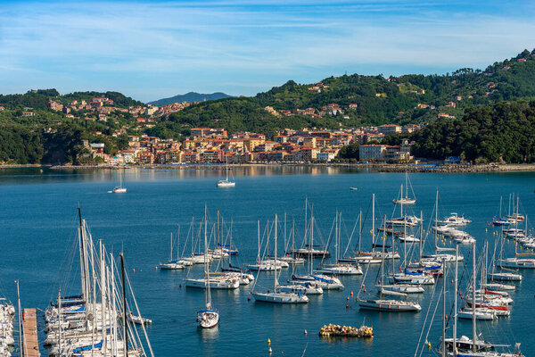 Port of Lerici town with many sailing boats moored and the small village of San Terenzo, tourist resorts on the coast of Gulf of La Spezia, Liguria, Italy, Southern Europe.