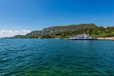 Garda Gölü kıyısındaki küçük Garda kasabasının önündeki sahil şeridi (Lago di Garda). San Vigilio Burnu (Punta San Vigilio) ile güzel bir körfez. Verona, Veneto, İtalya, Avrupa