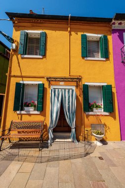 Güneşli bir bahar gününde Burano adasında parlak renkli (sarı ve yeşil) eski güzel bir ev. Venedik lagünü, Venedik, UNESCO dünya mirası sahası, Veneto, İtalya, Güney Avrupa.