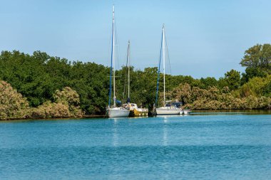İki yelkenli tekne ve Venedik gölüne demirlemiş bir katamaran Venedik, Venedik, Veneto, İtalya, Avrupa.