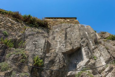 Liguria, La Spezia, İtalya ve Avrupa 'daki Cinque Terre Ulusal Parkı' ndaki Riomaggiore köyünün yakınındaki uçurumun kenarındaki tel örgüyle bir kaya düşme bariyerine yakın plan. UNESCO dünya mirası sahası.