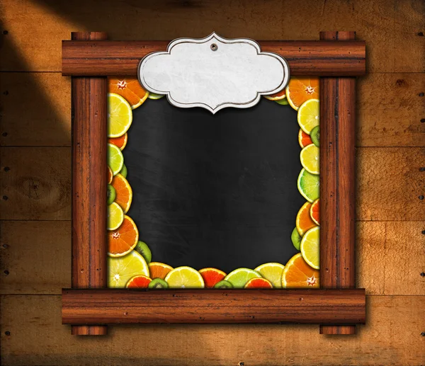 Quadro negro com moldura de madeira e frutas — Fotografia de Stock