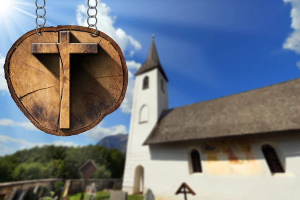 Houten kruis op de boomstam met kleine kerk — Stockfoto