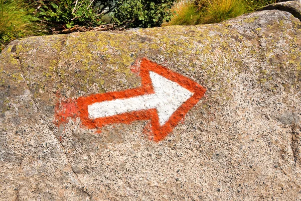 Freccia che segna un sentiero alpinistico su una roccia — Foto Stock