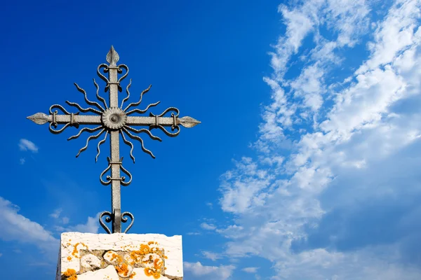 Wrought iron cross op blauwe hemel — Stockfoto