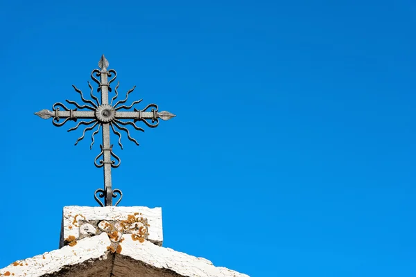 Schmiedeeisernes Kreuz am blauen Himmel — Stockfoto