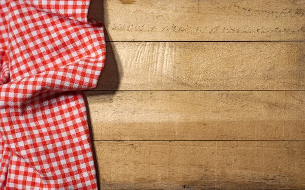 Rutig duk på träbord — Stockfoto