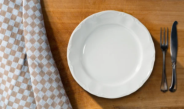 Белая тарелка и столовые приборы - Стол и скатерть — стоковое фото