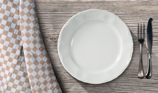 Тарілку і столові прилади на стіл з скатертиною — стокове фото