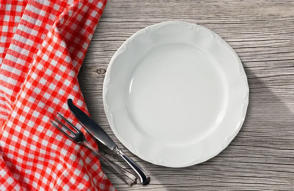Prato e talheres em uma mesa com toalha de mesa — Fotografia de Stock