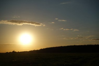 Dağlarda güzel bir gün batımı. Güneş, güneş ve mavi gökyüzü ile renkli bir manzara.