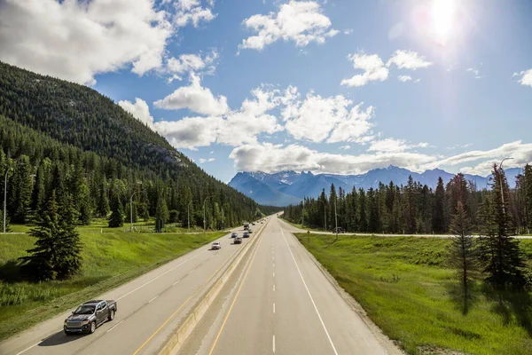 Dağ yolu otoyolu. Yaz zamanı, güneşli gün, bulutlu gökyüzü. Banff, Alberta, Kanada