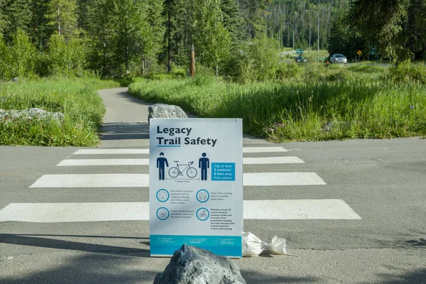Doğa Rocky Dağı Ulusal Parkı. Kasabadaki yol. Parkta trafik işareti var. Banff Notional Park 'taki Covid-19 sosyal mesafe tabelası. Alberta, Kanada