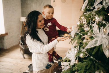 Oğluyla mutlu anne Noel ağacının yanındaki Noel süslerine bak..