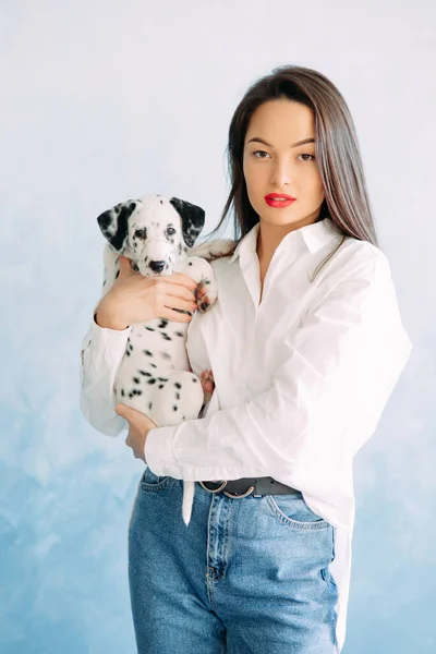 Young Woman Stands Puppy Dalmatian Dog Her Hands Blue Background — Stock Photo, Image