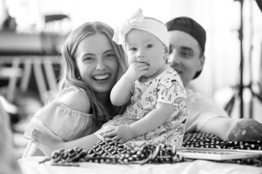 Genç ebeveynler eğleniyor ve küçük kızlarıyla oynuyorlar. Siyah ve beyaz resim.