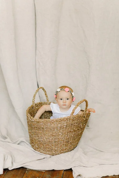 Baby Girl Wreath Her Head Sits Peeks Out Wicker Basket — Stock Photo, Image