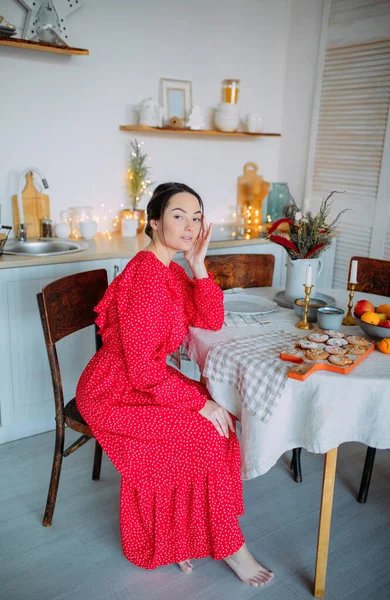 Молода Жінка Червоній Сукні Сидить Кухні Столом Задньому Плані Різдвяних — стокове фото