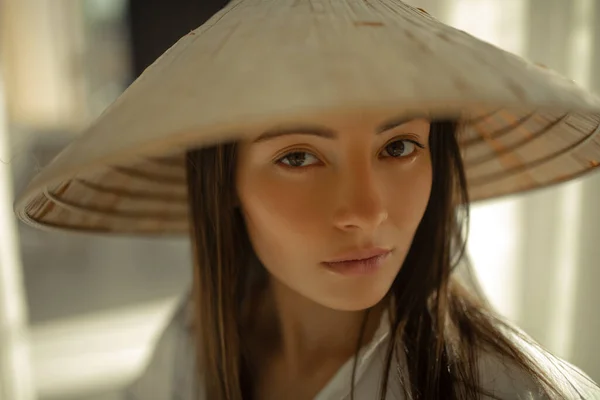 Portrait of young woman in vietnamese hat.