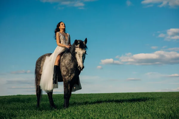 Noiva Vestido Branco Longo Senta Cavalo Cavalo Cinza Maçã Prado — Fotografia de Stock