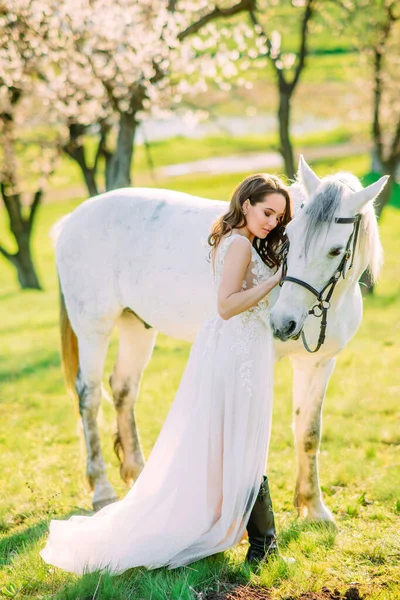 Bride Long White Dress Stands White Horse Embraces Spring Garden — Stock Photo, Image