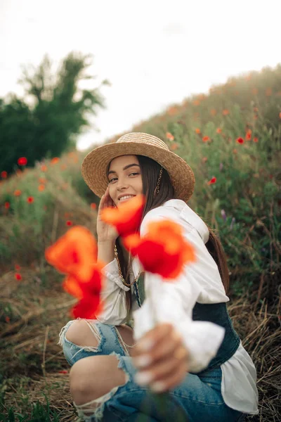 밀짚모자를 초원에 양귀비 꽃다발을 — 스톡 사진