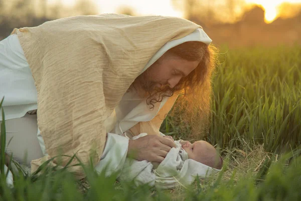 Sint Jozef Buigt Baby Jezus Liggend Gras Kijkt Naar Hem — Stockfoto