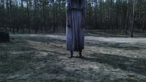 一个有着长长的黑头发的女孩在森林中走在石头井附近 她的形象是可怕的鬼魂僵尸 万圣节的概念 — 图库视频影像