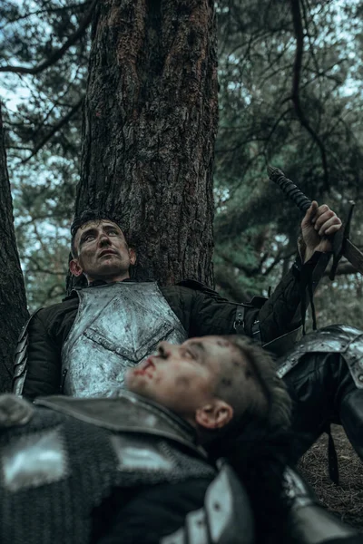 两个穿着链甲的疲惫的中世纪武士躺在树下的森林里 — 图库照片