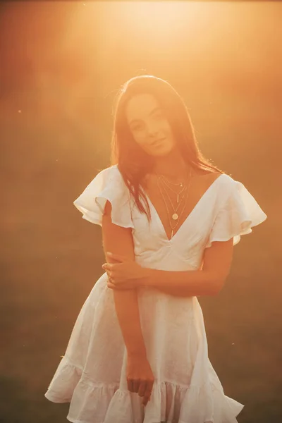 흰옷을 기뻐하는 여자는 여름날해질 초원에서 있습니다 백라이트 클로즈업 — 스톡 사진