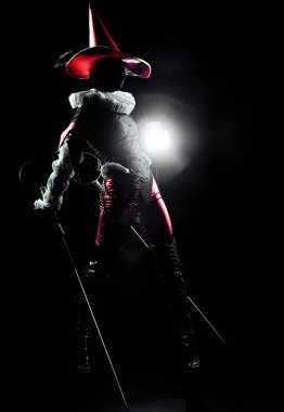 Bir soytarının dramatik silueti ya da çarpıcı bir kostümün içindeki palyaço figürü, siyah arkaplanda sert beyaz bir noktayla aydınlatılmış. Cadılar Bayramı kostümü ve teması.