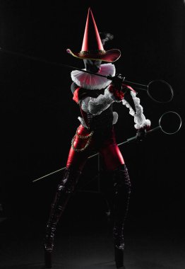 Siyah arka planda, üzerinde büyük baloncuk asalar olan, özenle hazırlanmış koyu fantezi bir soytarı kostümü giymiş gizemli bir Cosplayer ya da Cadılar Bayramı karakteri. Cadılar Bayramı fantezi.