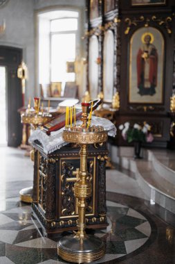 Altın şamdanlı, yanan mumlu, dini simgeli ve sunaklı bir Ortodoks kilisesinin içinde. Ruhani atmosfer, kutsal Hıristiyan geleneği, mekâna ibadet ve dini mimari detaylar.