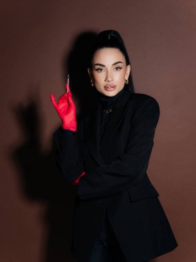 Zarif genç bayan kozmetolog doktor elinde şırınga tutan siyah ceketli kırmızı eldivenler. Estetik tıp Yaşlanma Karşıtı Güzellik Tedavi Konsepti.