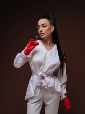 Zarif genç bayan kozmetik uzmanı ya da elinde şırınga tutan beyaz üniformalı hemşire. Estetik tıp Yaşlanma Karşıtı Güzellik Tedavi Konsepti.