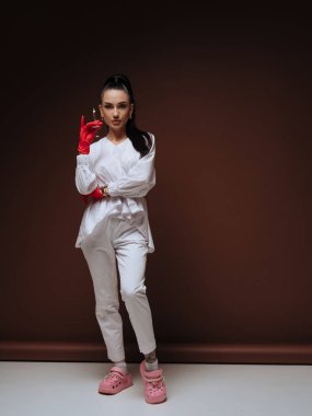 Zarif genç bayan doktor ya da hemşire kozmetolojist beyaz üniformalı kırmızı eldivenler ellerinde şırınga tutuyorlar. Estetik tıp Yaşlanma Karşıtı Prosedür.