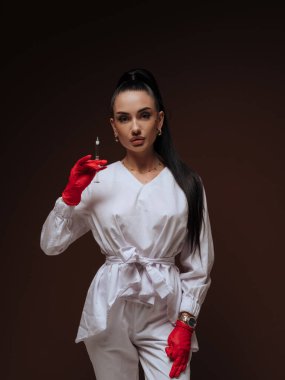 Zarif genç bayan kozmetik uzmanı ya da elinde şırınga tutan beyaz üniformalı hemşire. Estetik tıp Yaşlanma Karşıtı Güzellik Tedavi Konsepti.