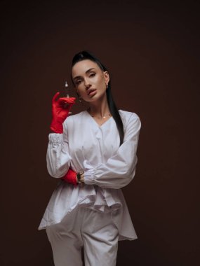 Zarif genç bayan kozmetik uzmanı ya da elinde şırınga tutan beyaz üniformalı hemşire. Estetik tıp Yaşlanma Karşıtı Güzellik Tedavi Konsepti.