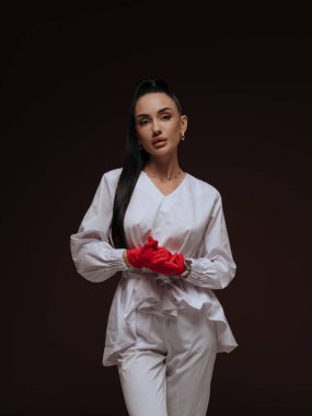 Zarif genç bayan doktor ya da hemşire kozmetolog beyaz üniformalı kırmızı eldivenler katlanmış. Profesyonel estetik tıp tedavi hizmeti konsepti.