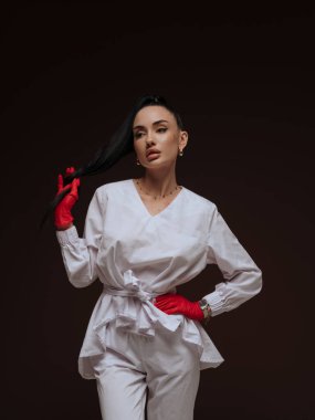 Beyaz üniformalı genç bayan doktor ya da hemşire kozmetik uzmanı ve moda elbisesi giymiş kırmızı eldivenler. Profesyonel estetik tıp güzellik kliniği hizmeti konsepti.