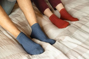 The legs of a man and a woman are tucked into socks. close-up. dark red and blue colors. clipart