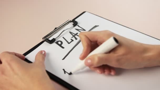 Feche a mão da menina escrevendo no bloco de notas. Escreva um plano com um marcador no white paper. — Vídeo de Stock