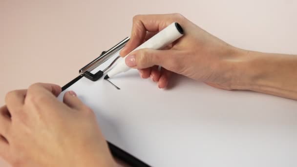 Sluiten van meisje hand schrijven op notitieblok. Schrijf een plan met een markering op wit papier. — Stockvideo