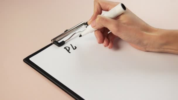 Primer plano de la escritura a mano de chica en el bloc de notas. Escribe un plan con un marcador en papel blanco. — Vídeos de Stock