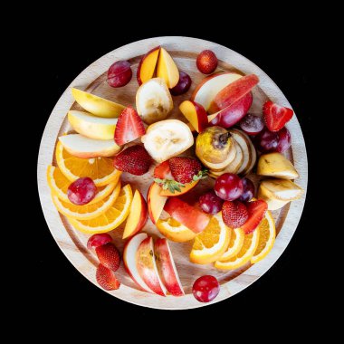 Meyve kesimi tabakta. Apelsygs, üzüm, elma ve çilek.