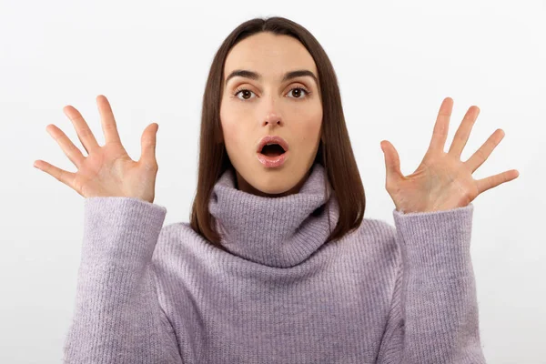 Sorprendido morena feliz mujer en suéter se regocija y mirando a la cámara sobre fondo blanco —  Fotos de Stock