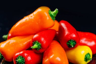 Taze dolmalık biberler renkli bir arka plan yaratıyor, telif hakkı için bir yer. Su sıçramalı siyah arkaplan.