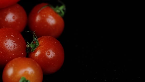 Apetitivos tomates maduros sobre un fondo negro espejo. Mesa giratoria y tomates rojos. Concepto de comer, cocinar y diseñar. — Vídeos de Stock