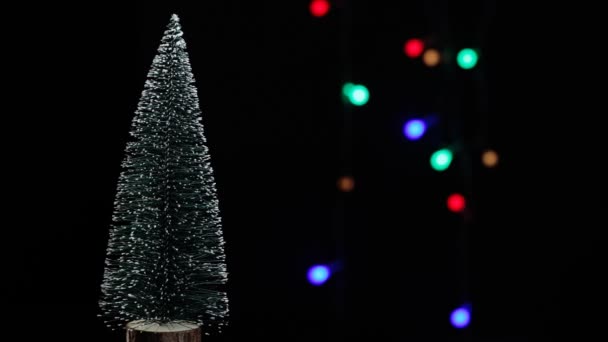 Nový rok. Zelený vánoční stromek na barevném pozadí bokeh. rotace 360 — Stock video